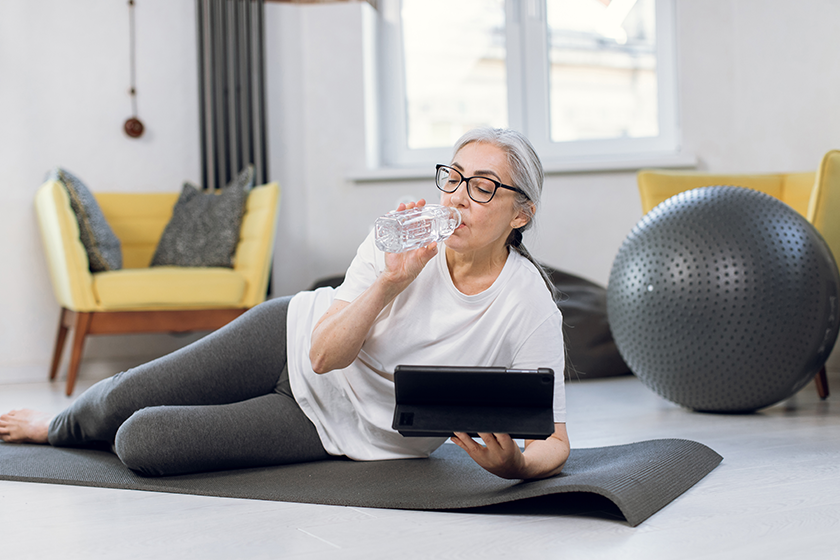 Elderly woman using tablet while training